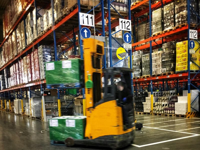Gabelstapler transportiert Paletten durch ein Hochregallager